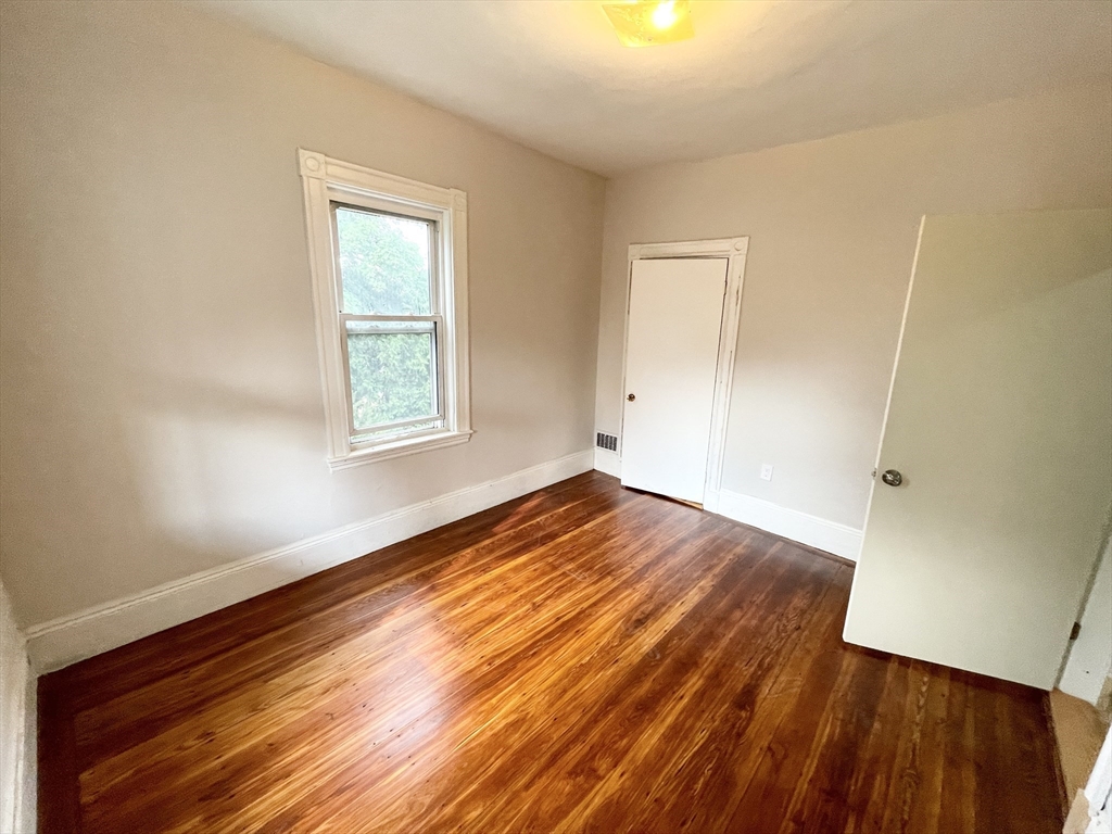 10 Wave Avenue, Unit 2 Boston, MA 02125 - Photo 9 of 15 an empty room with wooden floor and windows