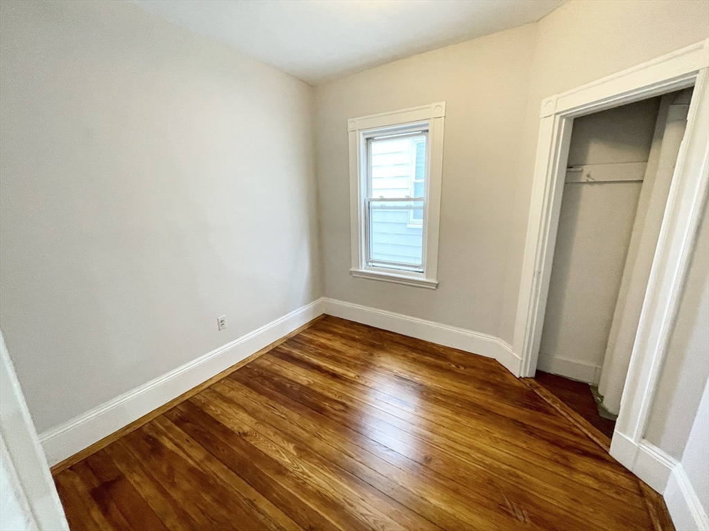 10 Wave Avenue, Unit 2 Boston, MA 02125 - Photo 10 of 15 an empty room with wooden floor and windows
