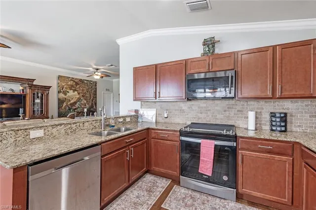 a kitchen with stainless steel appliances granite countertop a sink stove and microwave