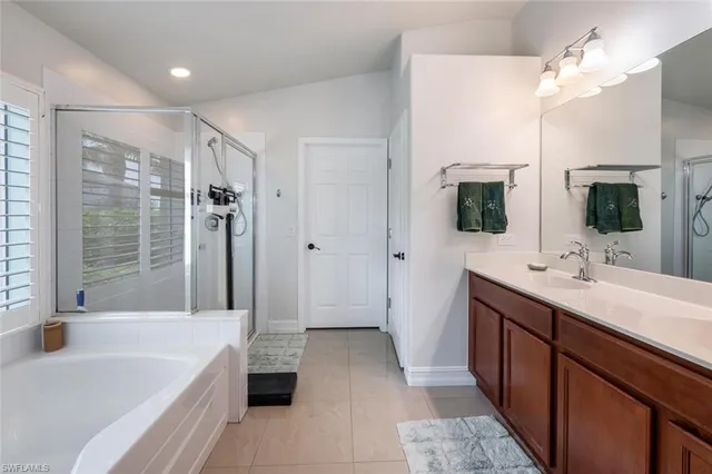 a bathroom with a tub a sink and mirror