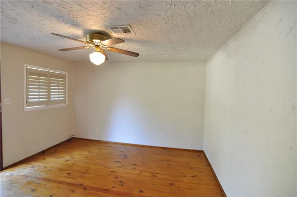 a view of an empty room and wooden floor