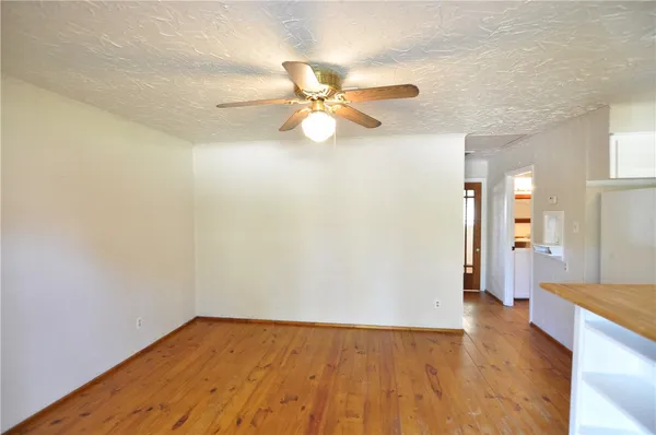 a view of an empty room and window with wooden floor