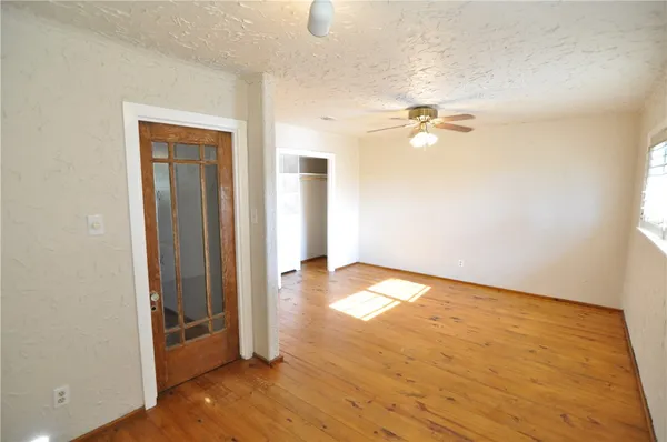 an empty room with wooden floor and windows