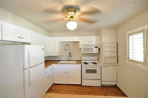 a kitchen with white cabinets and white appliances