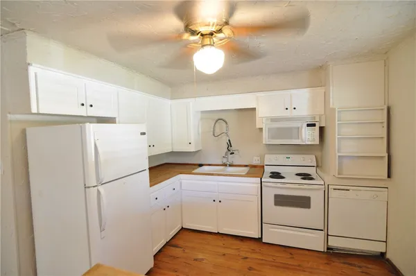 a kitchen with white cabinets and white appliances