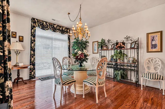a dining room with furniture entryway and wooden floor