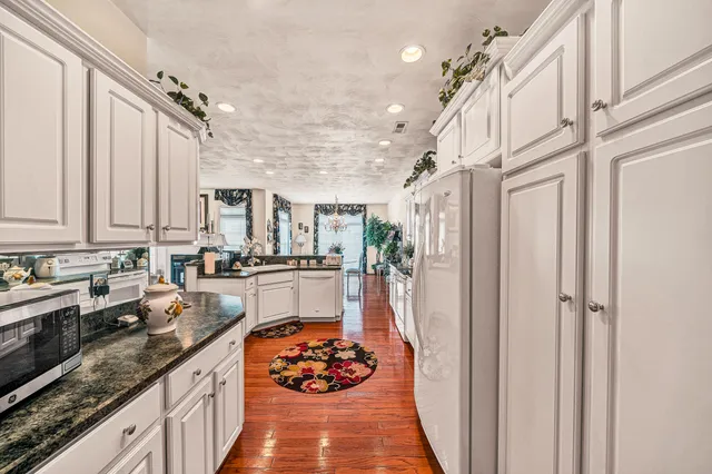 a kitchen with stainless steel appliances granite countertop a sink stove and cabinets
