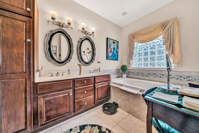 a bathroom with a sink mirror vanity and bathtub