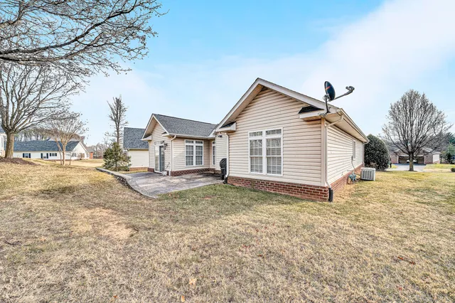 a view of a white house in the middle of a yard