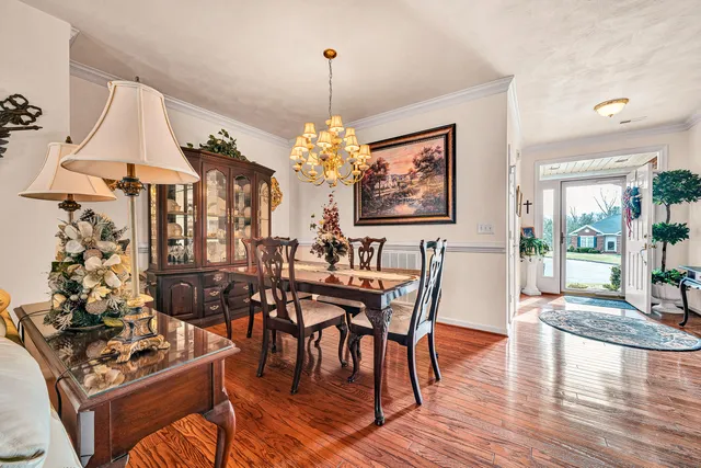 a view of a dining room with furniture a chandelier and wooden floor