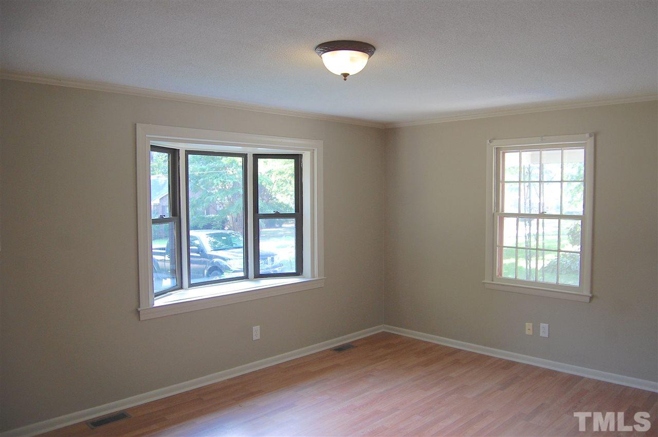 1009 Somerset Road Raleigh, NC 27610 - Photo 7 of 13 a view of an empty room with wooden floor and a window