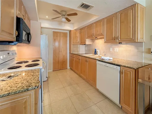 a kitchen with stainless steel appliances granite countertop a stove a sink and a refrigerator