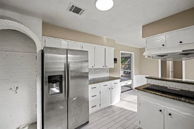 a kitchen with stainless steel appliances a refrigerator sink and cabinets