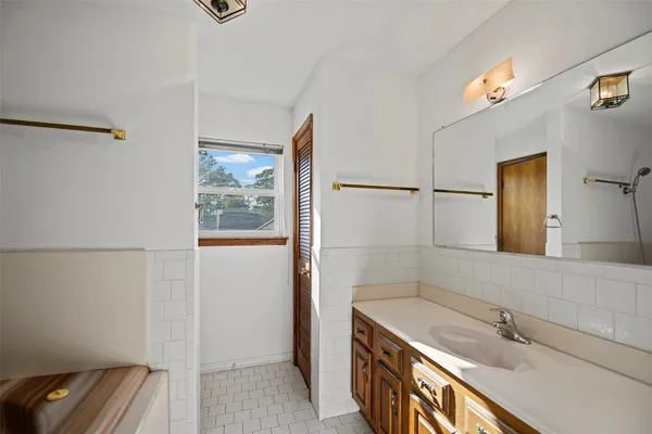 a bathroom with a granite countertop sink a mirror and a shower
