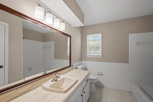 a bathroom with a sink a toilet and a mirror