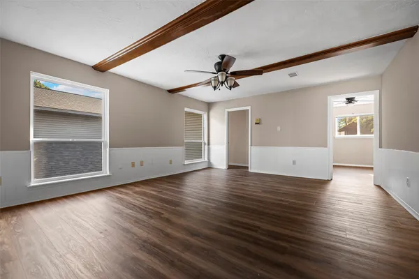 a view of a livingroom with wooden floor and a ceiling fan