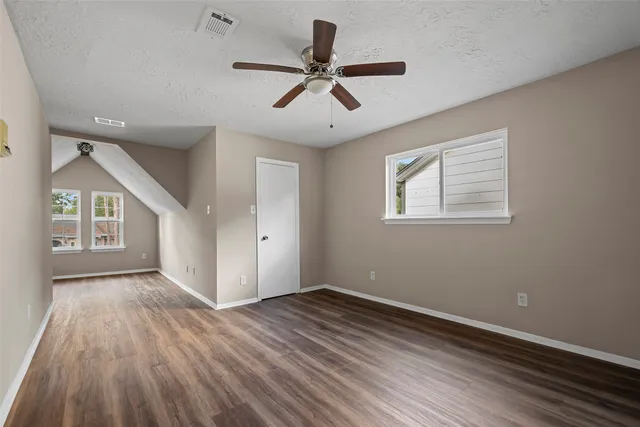 a view of empty room with wooden floor
