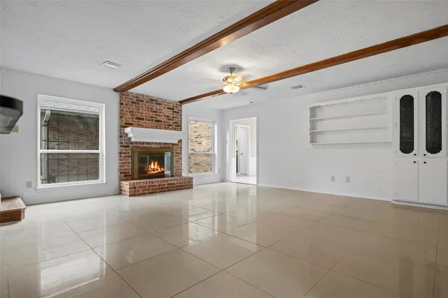 a view of an empty room with a fireplace and a window