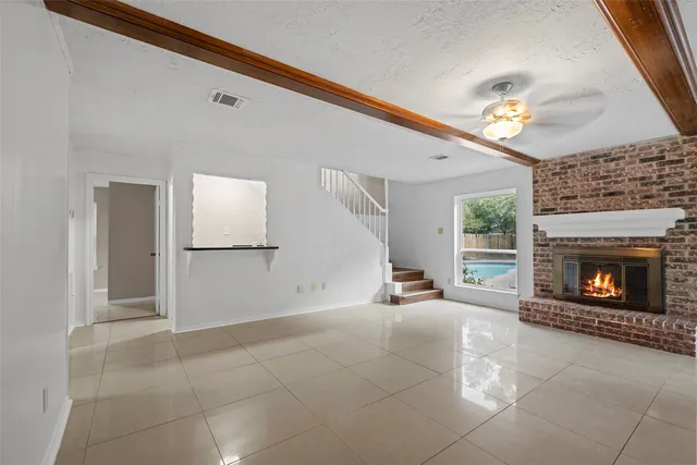 a view of a livingroom with fireplace and window
