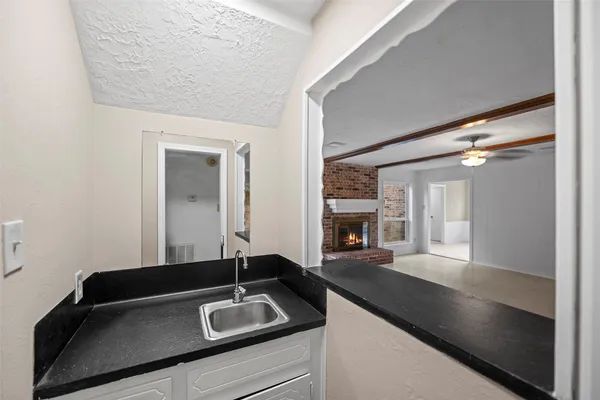 a bathroom with a granite countertop sink and a large mirror