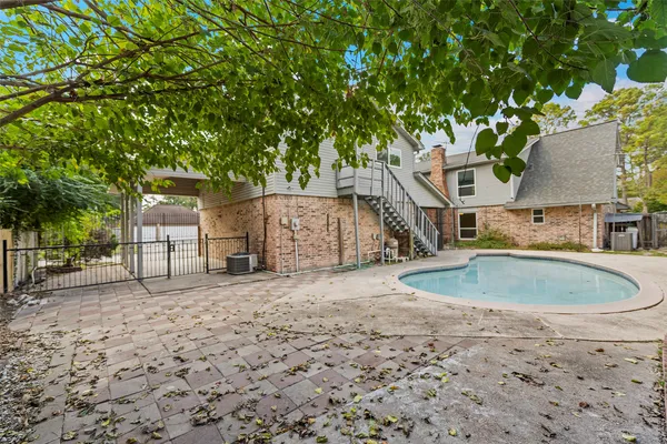 a backyard of a house with large trees and plants