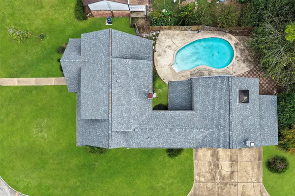 a aerial view of a house with a swimming pool and a yard