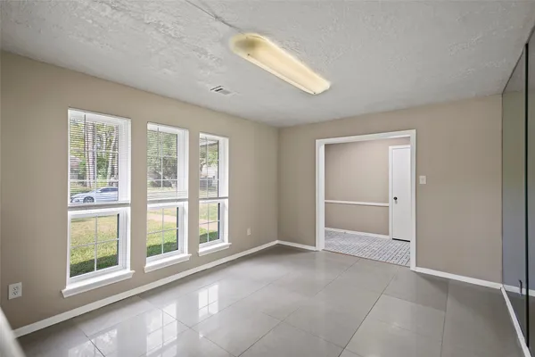 an empty room with windows and closet