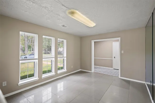 an empty room with windows and closet