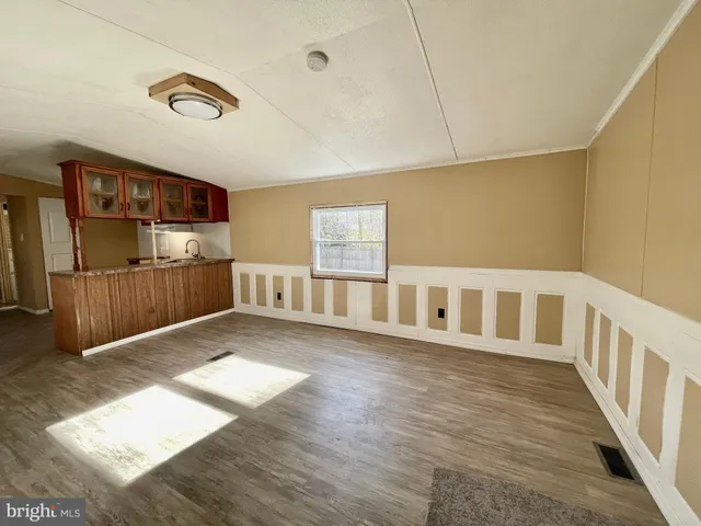 a view of an empty room with kitchen