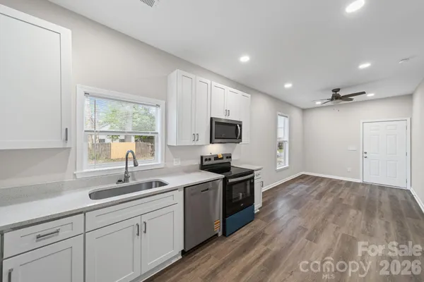 a kitchen with granite countertop a sink and steel appliances