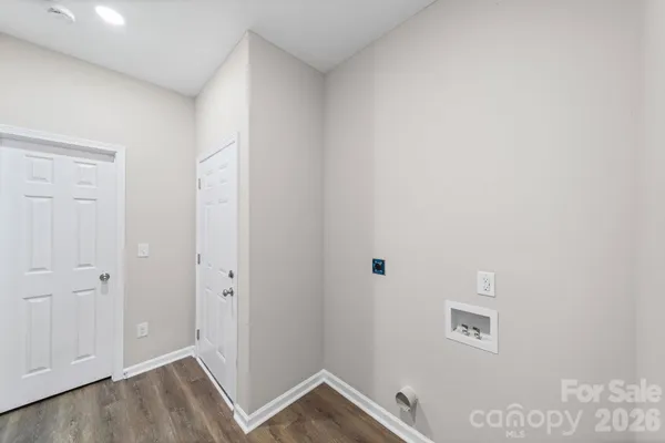 a view of a room with wooden floor and a hallway