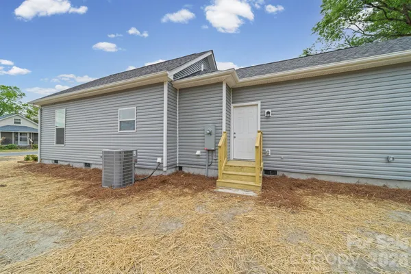 a view of backyard of house and car parked