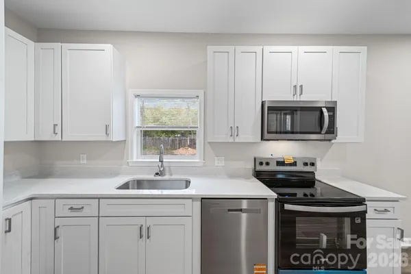a kitchen with a sink and a stove top oven