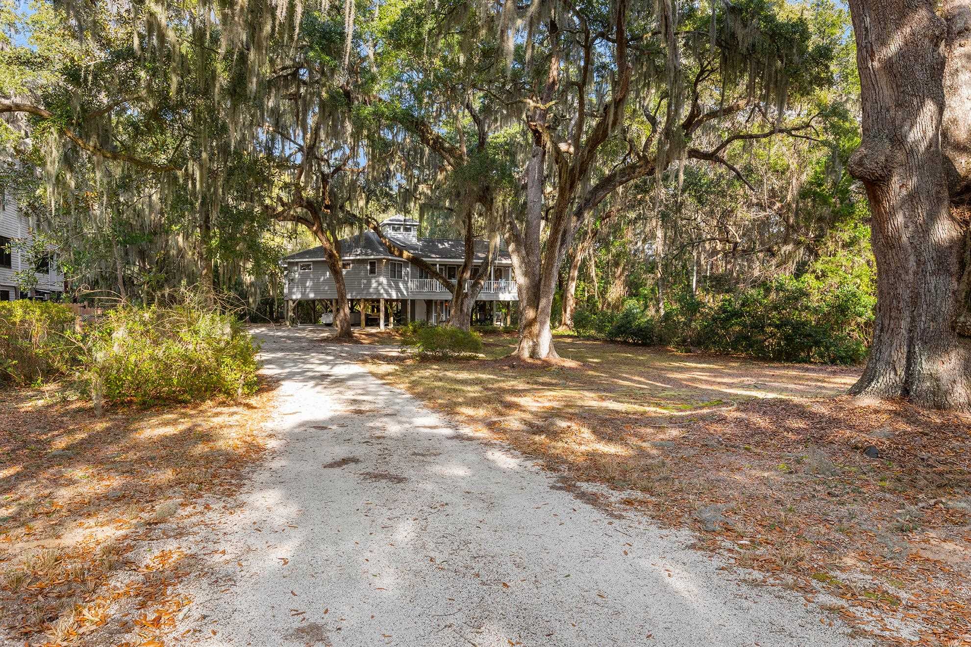 187 Alston Road Pawleys Island, SC 29585 - Photo 2 of 40 View of front facade featuring driveway and view of scattered trees