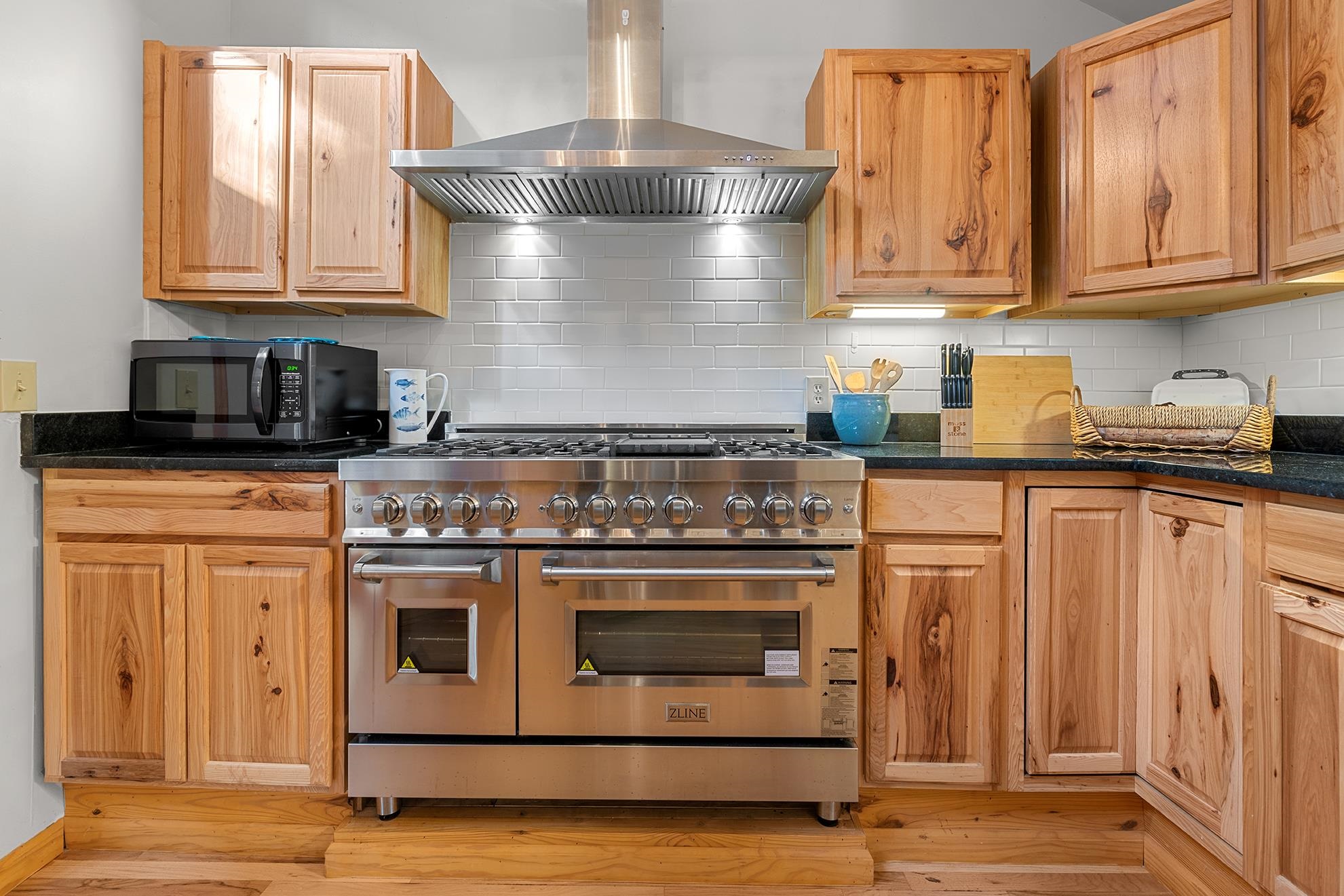 187 Alston Road Pawleys Island, SC 29585 - Photo 21 of 40 Kitchen featuring range with two ovens, wall chimney range hood, decorative backsplash, and dark stone countertops