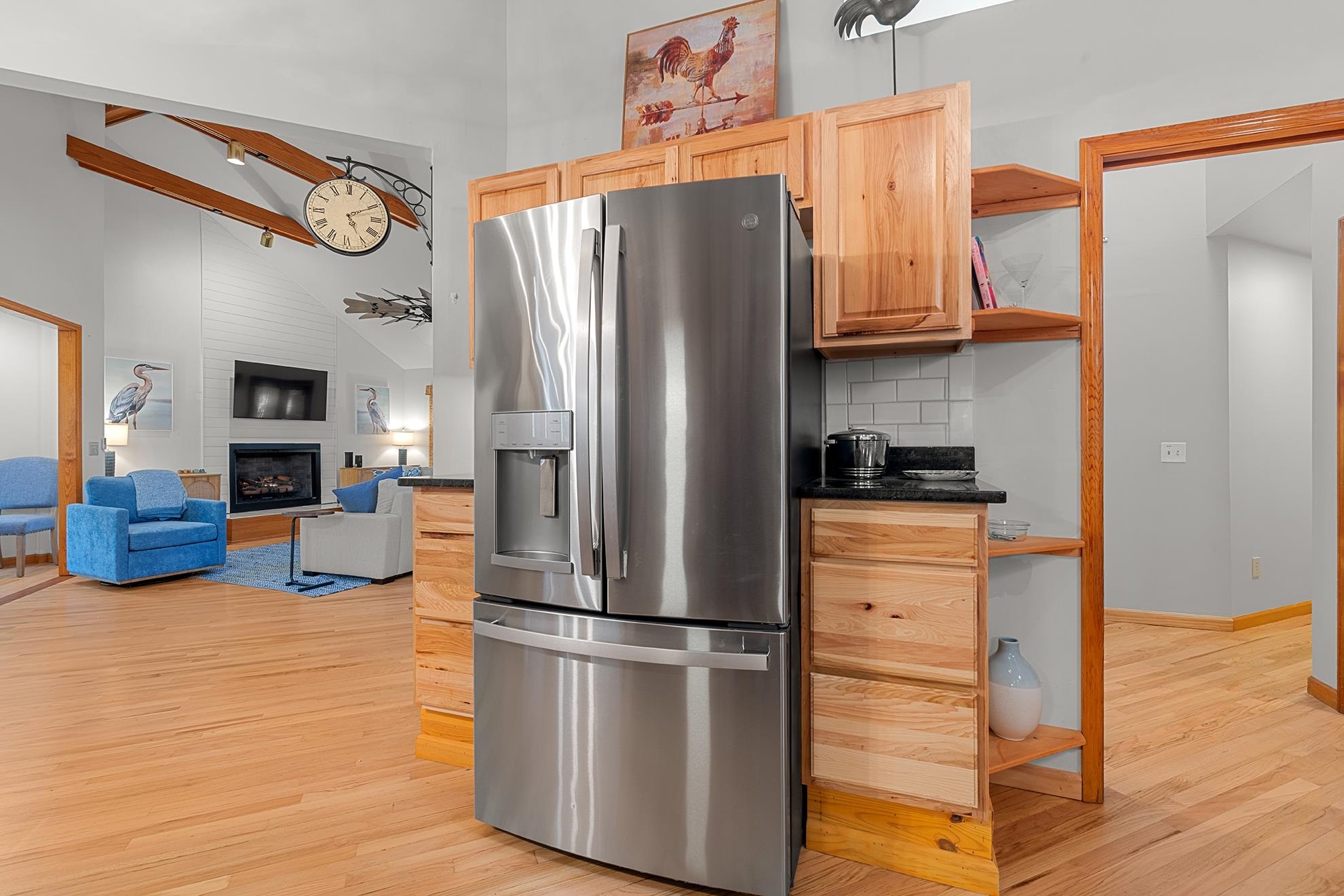 187 Alston Road Pawleys Island, SC 29585 - Photo 22 of 40 Kitchen featuring stainless steel fridge, dark stone counters, open shelves, light wood-style flooring, and light brown cabinets