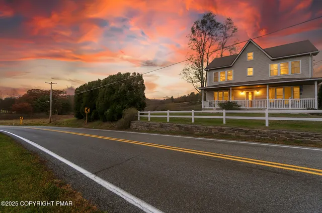 a view of a house with a big yard and large trees