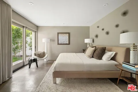 a bedroom with a bed and a large window