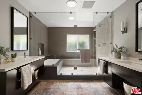 a large bathroom with a double vanity sink a mirror and a bathtub
