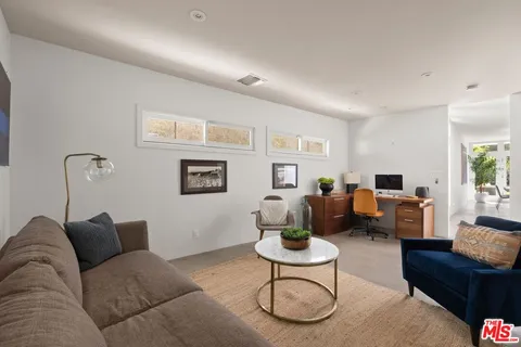 a living room with furniture a rug and a window