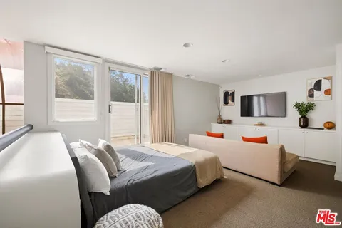 a bedroom with a bed wooden floor and window