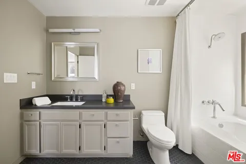a bathroom with a granite countertop sink mirror and toilet