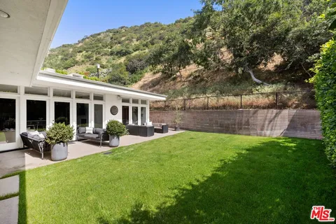 a view of a house with backyard sitting area and garden