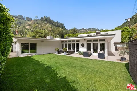 a view of a house with a yard and sitting area
