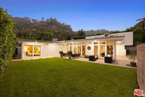 a view of a house with backyard sitting area and garden