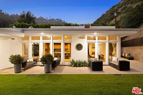 a view of a house with backyard porch and sitting area