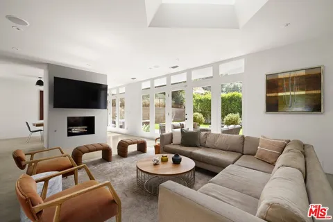 a living room with furniture a flat screen tv and a large window