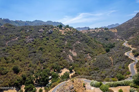 a view of a dry yard with mountains in the background