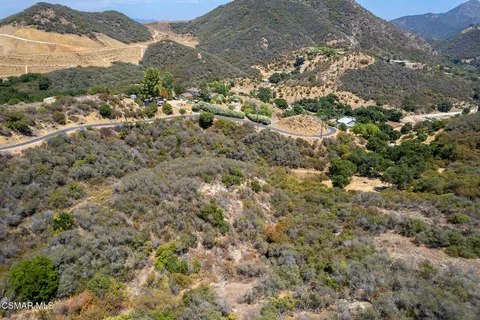 a view of a forest with mountains in the background