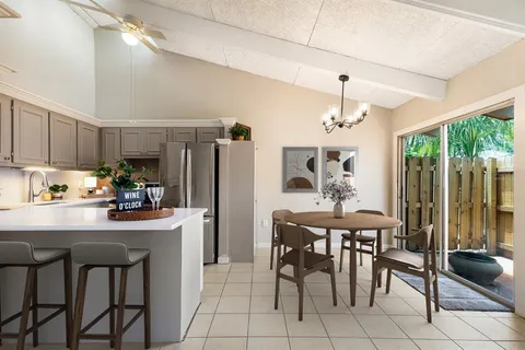 a kitchen with stainless steel appliances a dining table chairs and granite counter tops